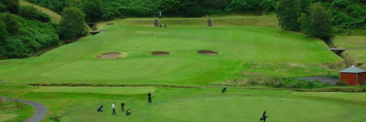 Looking down on two of the greens at Glencruitten Golf Club, with a burn running between them