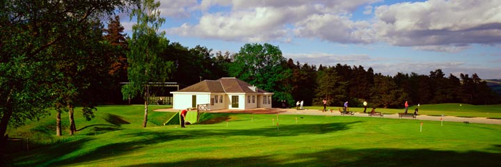 A golfer placing a Gleneagles golf ball on a golf tee