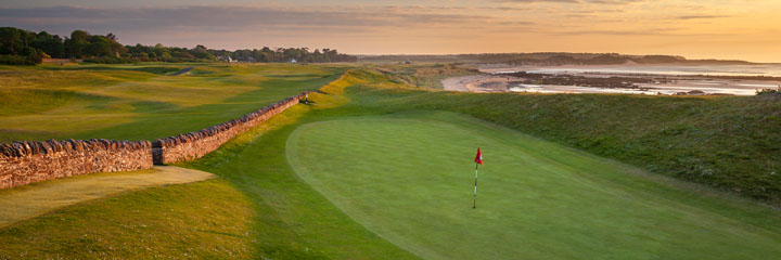 The 13th hole at the North Berwick West Links - Pit - with the beach in the background and a wall separating the green from the fairway.